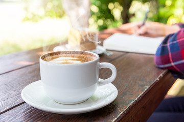 Close up cup of hot coffee on wooden table
