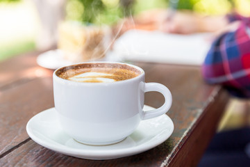 Close up cup of hot coffee on wooden table