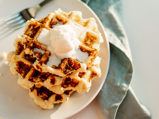 Ricotta cheese chaffles for keto diet. Stack of ricotta and lemon belgian waffles decorated with ice cream scoop. Copy space for text. Natural sunset or sunrise daylight. Top view or flat lay