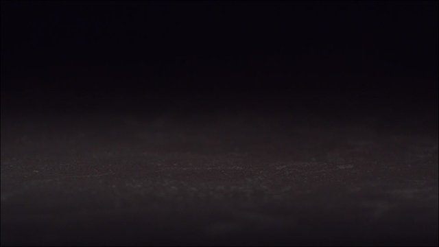 Egg falling and breaking  in slow motion on black tile surface. High speed 1600 frames per second.