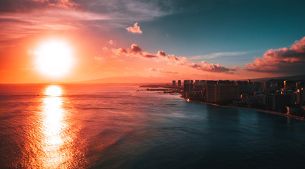Top view of beautiful sunset in Hawaii island with building and ocean, aerial drone shot