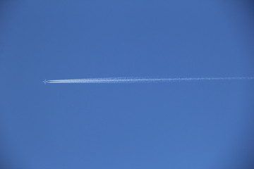 青空に一直線に伸びる飛行機雲
