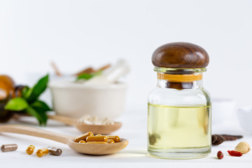 Herbal supplement in capsules on wooden spoon with healthy medicinal plant.Alternative drug or natural pharmaceutical capsule.Medication of vitamin supplemental for care and treatment.