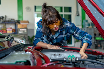 Asian young female car repair worker.