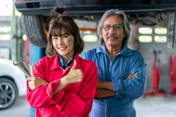 Team of Asian Mechanics Smiling and Giving Thumb Up.