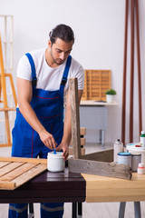 Young male contractor working in workshop