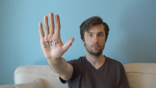 Young man showing stop sign on the hand. Movement against sexual harassment.