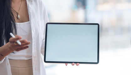 woman holding blank screen tablet presenting business plan.
