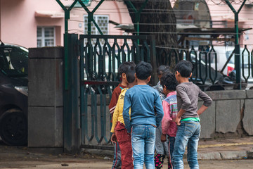 A group of poor children from different households gathering together and standing closely while violating social distancing and stay home norms during Covid 19 or corona virus outbreak in India.
