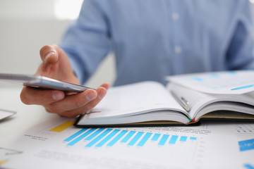 A businessman holds a new smartphone in his hand The mobile application market shows a display you can insert your image for advertising or financial statistics.