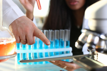 A female doctor in a chemical laboratory holds a tablet in his hand with display, you can insert a...