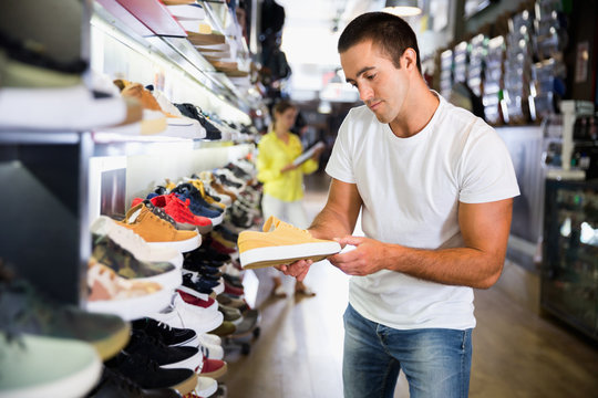Portrait Of Man Buying Sneakers During Shopping In Shoe Shop