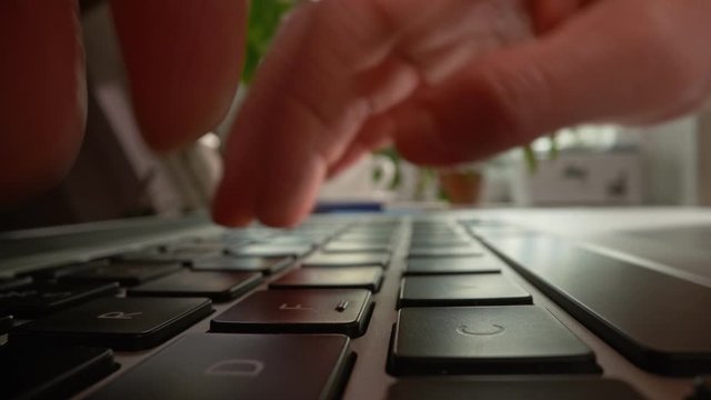 Shot with probe lens, inside view. Woman hands typing laptop keyboard. Woman working on her laptop at home or office. Slider shot, 4K