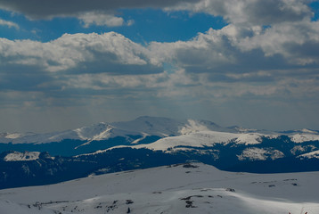 mountain with snow and sun in the clouds