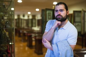 Man looking at stone architectural elements in historical museum hall