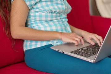 Naklejka premium Midsection of young woman using laptop