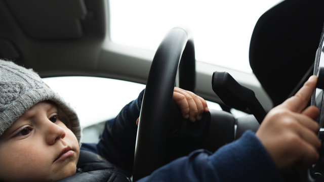 Smart Serious Cute Toddler Boy Learning To Drive A Car. Funny Conceptual Portrait Photo. 