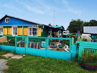 Fototapeta na wymiar Fabulous beautiful mulyi-colored rural house with a metal fence and gates.Russia.