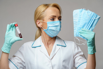 medical doctor nurse woman wearing latex gloves - holding virus blood test and protective mask