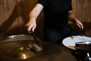 
Professional drum set closeup. Man drummer with drumsticks playing drums and cymbals, on the live music rock concert or in recording studio   
