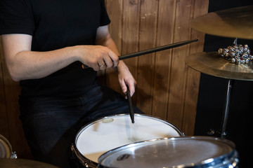 
Professional drum set closeup. Man drummer with drumsticks playing drums and cymbals, on the live music rock concert or in recording studio   
