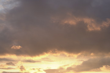 Beautiful evening blue sky at sunset with flaming bright light clouds. A warm summer evening at sunset.