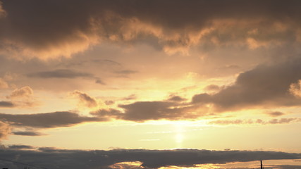 Fototapeta premium Beautiful evening blue sky at sunset with flaming bright light clouds. A warm summer evening at sunset.