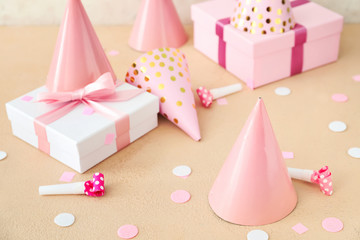 Party hats and gift boxes on light background