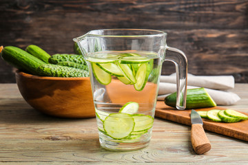 Jug of infused cucumber water on table