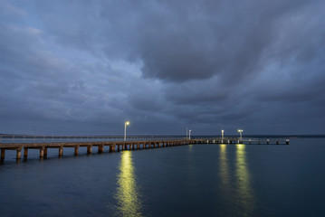 Fototapeta na wymiar Corinella Pier early morning Dark clouds above