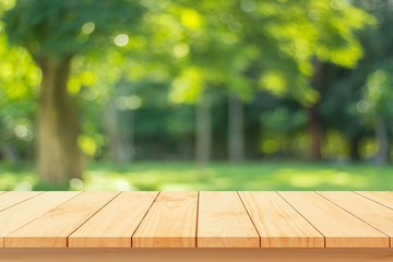 Wood floor with blurred trees of nature park background and summer season, product display montage