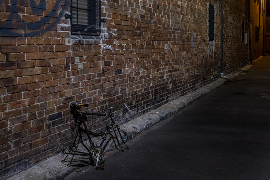 abandoned bicycle  has parets stolen in alley at night
