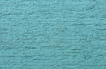 old light blue brick wall with a thick layer of paint
