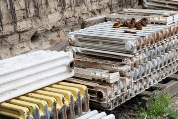 Replacing heating radiators: a stack of old cast iron radiators