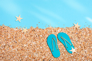 Summer slippers on beach with sand under sunlight, summer background with copy space. Pastel...