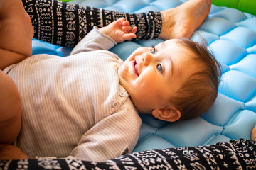 Baby infant toddler lay on mattress looking at adult parent. Childhood