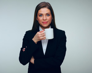 Confident business woman in black suit holding white cup.