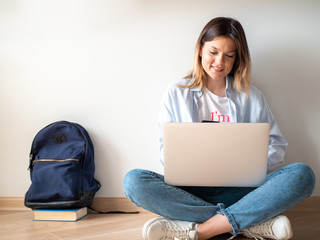 Portrait of cheerful student with laptop isolated on white