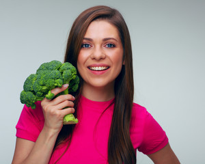 face portrait of woman in red dress holding green broccoli.