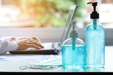 sanitizer gel for hand hygiene and medical surgical masks on doctor table , stop spreading outbreak coronavirus ,health care concept.
