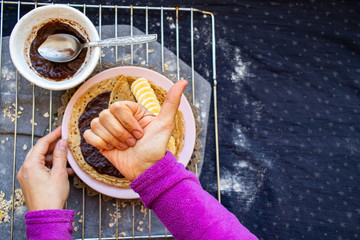 Crepes with chocolate and bananas or thin pancakes. Vegan food sweet breakfast. Woman hands show "like" with big finger up