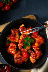 Spicy chicken wings in honey with potato wedges