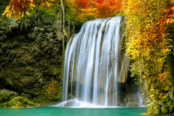 Colorful majestic waterfall in national park forest during autumn