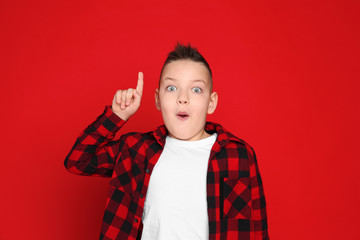 Portrait of emotional little boy on red background