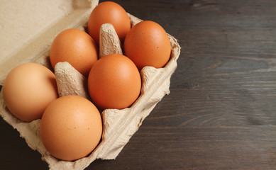 Paper Box of Organic Chicken Eggs Isolated on Wooden Table with Copy Space	