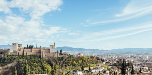 Fototapeta na wymiar Panoramic view of the Alhambra in Granada with the city in the background a sunny day with blue sky and white clouds.