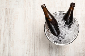 Beer in metal bucket with ice on white wooden table, top view. Space for text © New Africa