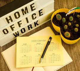 lightbox with text HOME OFFICE WORK with notebook pen and cactus calendar 2020 and TO DO list, copy...