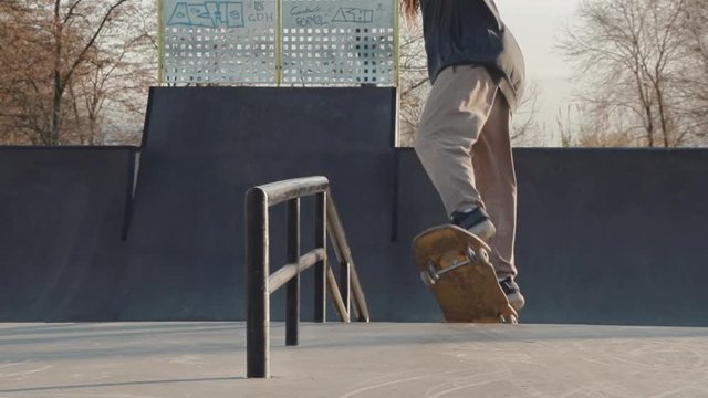 Close shot in slowmotion of a skateboarder doing a frontside board slide with rotation out on the last lights of the day.
