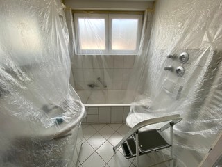 covered bathroom walls with tarp and ladder in preparation for painting - house renovation concept